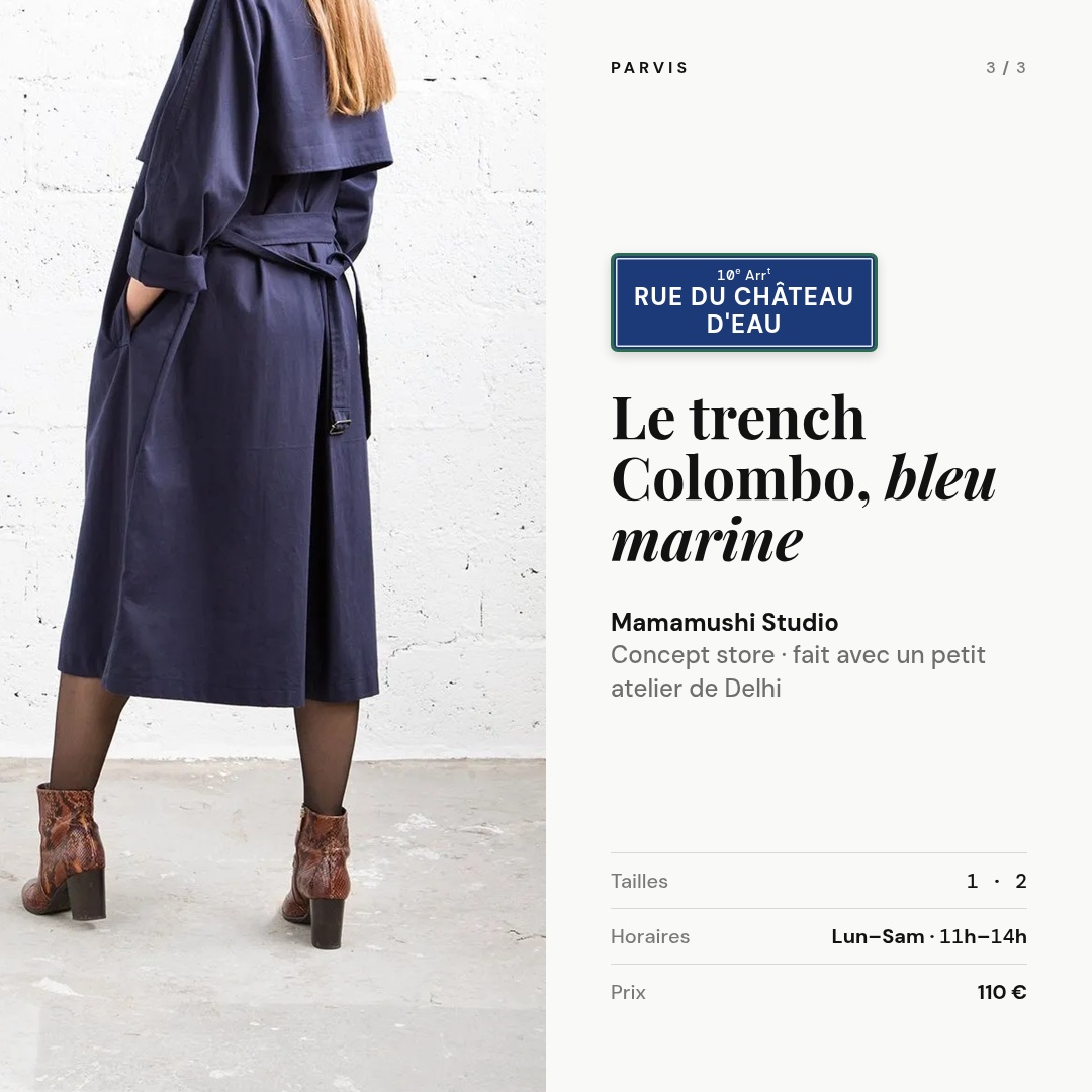 Long trench bleu marine ceinturé vu de dos devant un mur blanc. Plaque « Rue du Château d'Eau, 10e arrondissement ». Le trench Colombo, bleu marine — Mamamushi Studio, concept store, 110 €. Tailles 1 et 2. Ouvert du lundi au samedi de 11 h à 14 h.